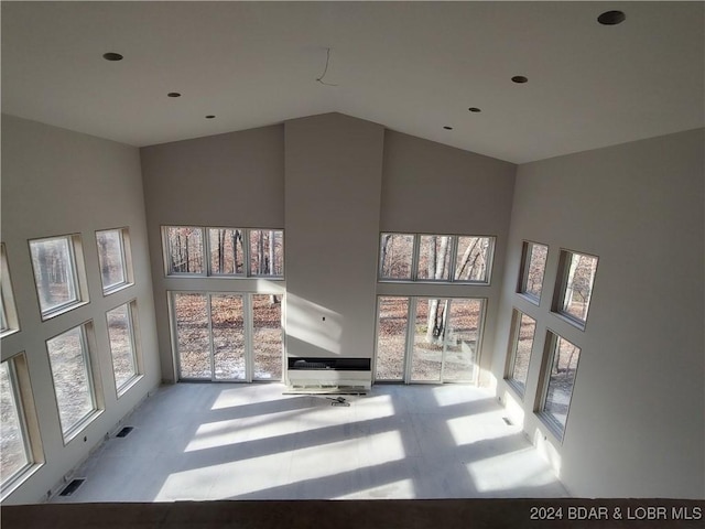 unfurnished living room featuring a towering ceiling