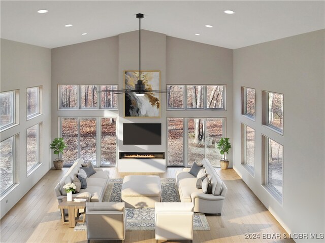 living room with a towering ceiling and light hardwood / wood-style floors