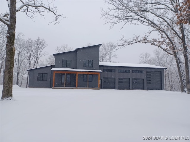 snow covered rear of property featuring a porch