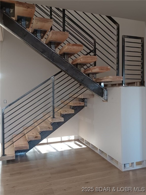 stairway with hardwood / wood-style flooring