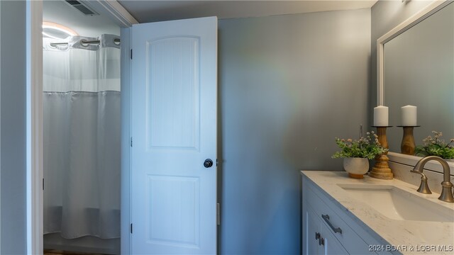 bathroom featuring vanity and shower / bath combination with curtain