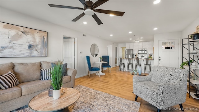 living room featuring ceiling fan and light wood-type flooring