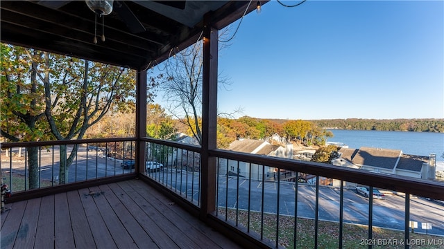 deck with ceiling fan and a water view