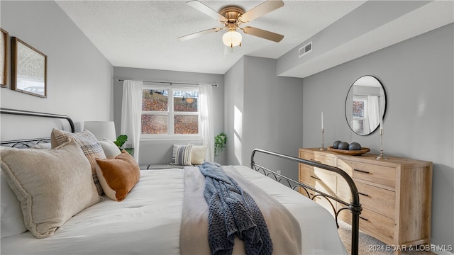 bedroom with carpet flooring, ceiling fan, and a textured ceiling