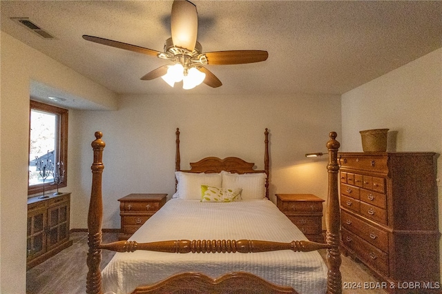 carpeted bedroom with ceiling fan and a textured ceiling