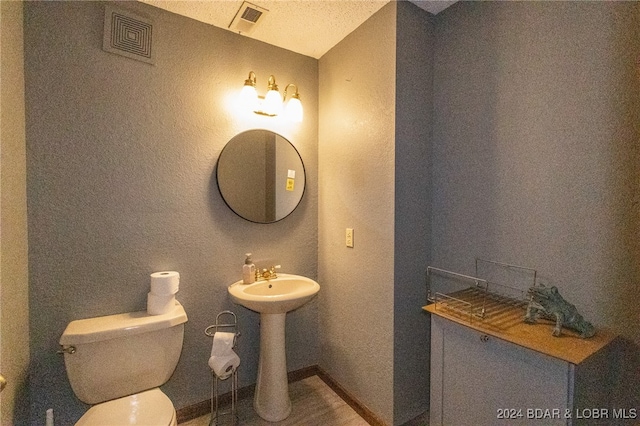 bathroom with a textured ceiling and toilet