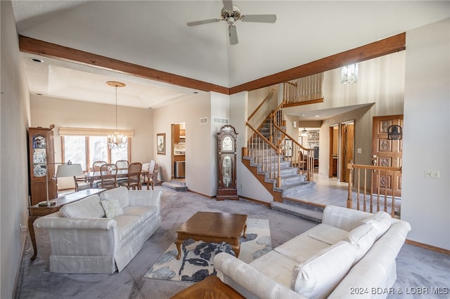 carpeted living room with ceiling fan with notable chandelier and a towering ceiling