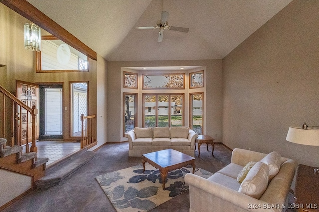 living room featuring ceiling fan with notable chandelier, dark carpet, and high vaulted ceiling