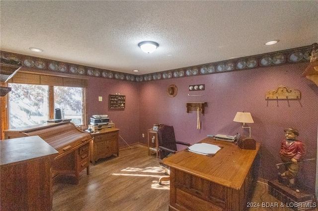 home office with hardwood / wood-style flooring and a textured ceiling