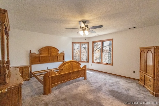 bedroom featuring carpet flooring, ceiling fan, and a textured ceiling