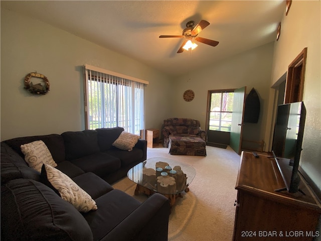 carpeted living room with ceiling fan and lofted ceiling