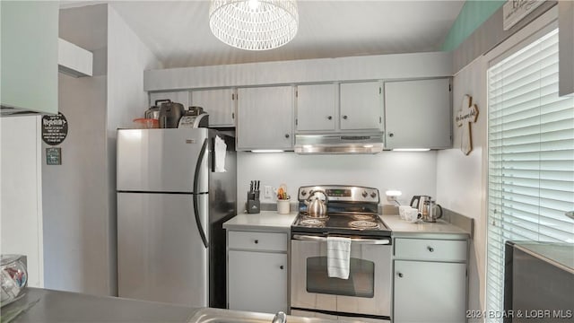 kitchen featuring plenty of natural light, stainless steel appliances, and a notable chandelier