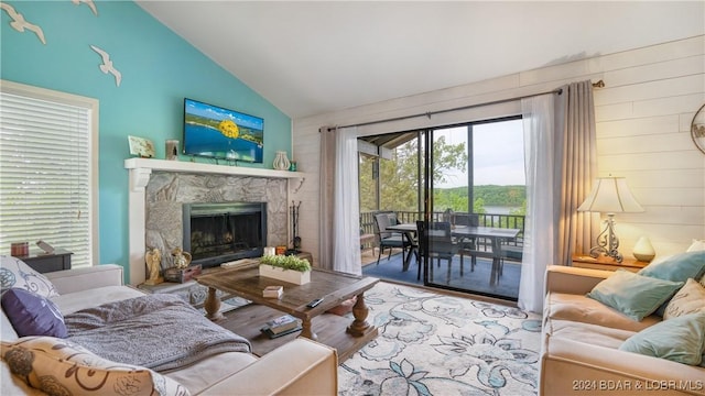 living room with wood-type flooring, vaulted ceiling, and a premium fireplace