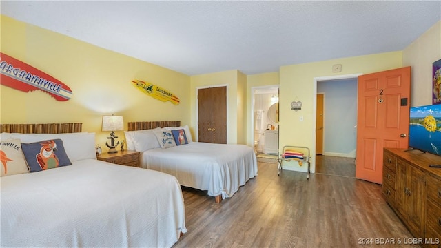 bedroom with dark hardwood / wood-style flooring and a textured ceiling