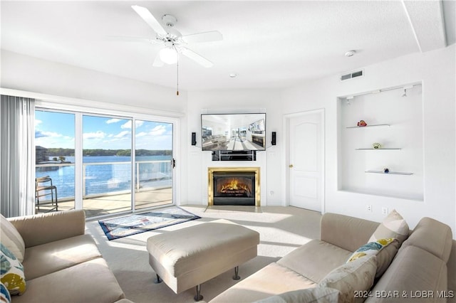 carpeted living room featuring ceiling fan and built in shelves