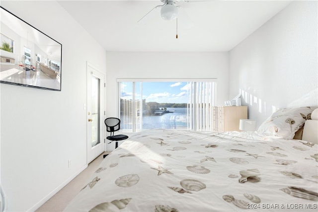 unfurnished bedroom with a water view, access to outside, and ceiling fan