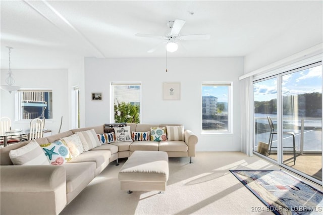 carpeted living room with ceiling fan