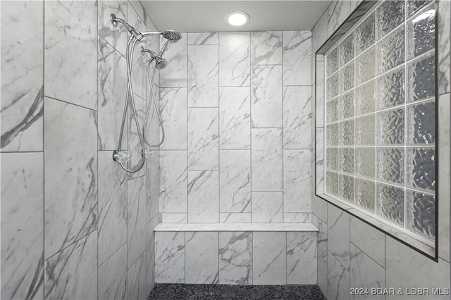 bathroom featuring tiled shower and a textured ceiling