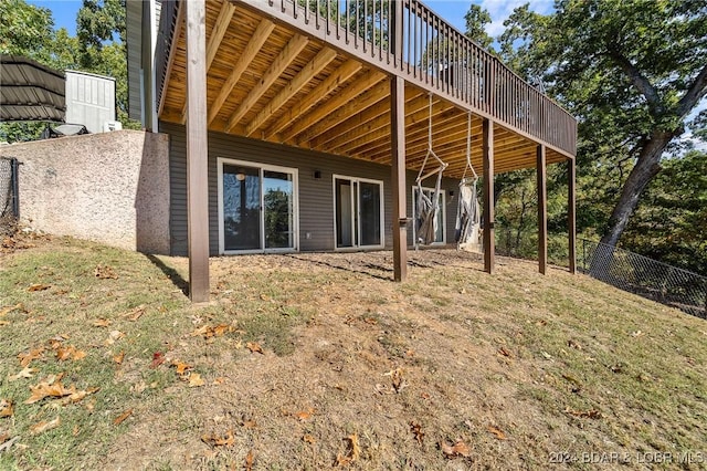 rear view of house featuring a wooden deck and a yard