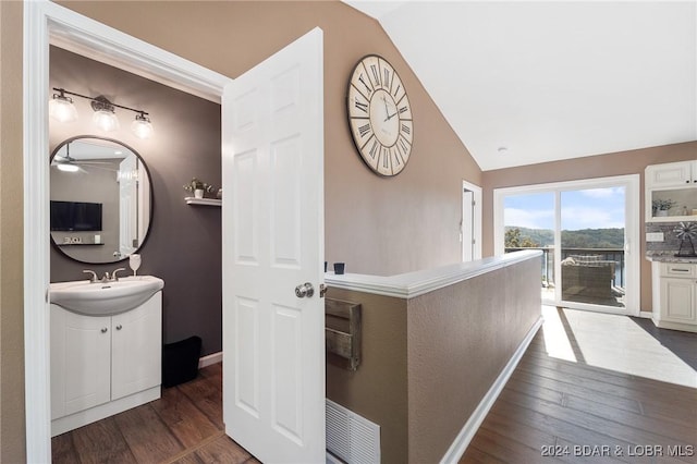 hall with vaulted ceiling, sink, and dark hardwood / wood-style flooring