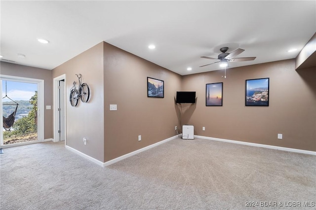 unfurnished room with light colored carpet and ceiling fan