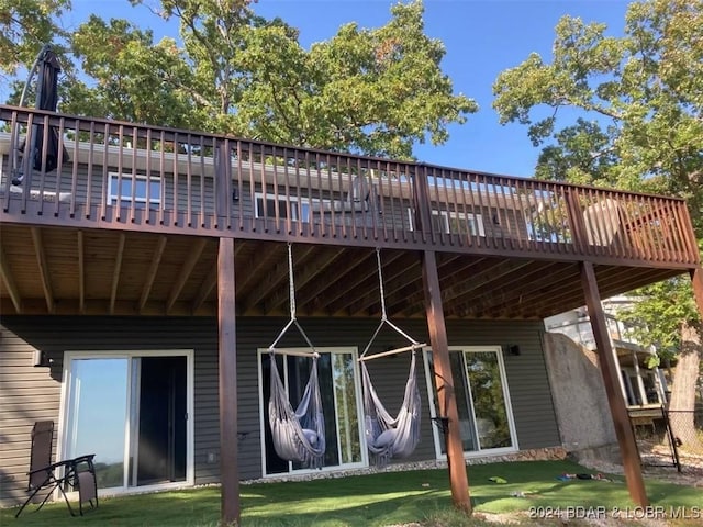 rear view of house with a deck and a lawn