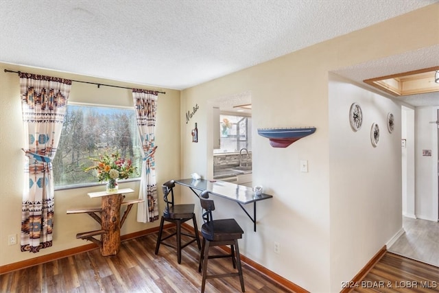 dining area featuring hardwood / wood-style floors, a textured ceiling, and sink