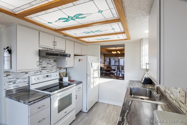 kitchen featuring a notable chandelier, backsplash, light hardwood / wood-style floors, white appliances, and white cabinets