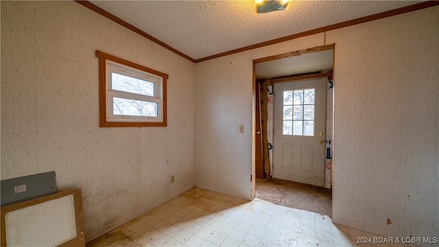 doorway featuring a textured ceiling and crown molding