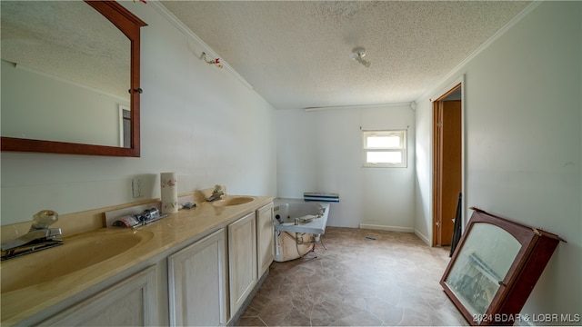 bathroom with a washtub, vanity, a textured ceiling, and ornamental molding