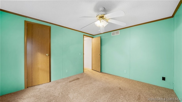 unfurnished bedroom with a textured ceiling, ceiling fan, crown molding, and light carpet