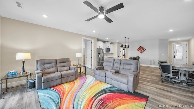 living room with hardwood / wood-style flooring and ceiling fan