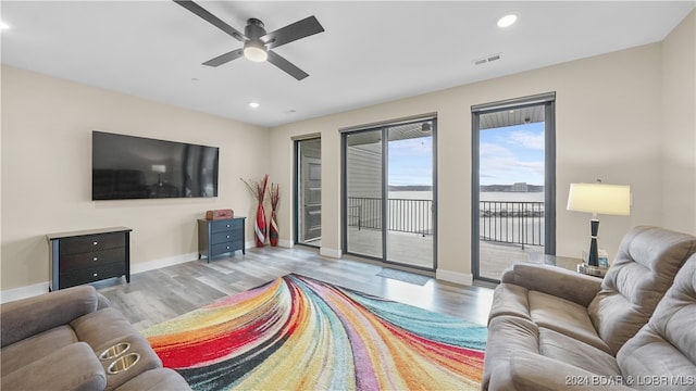 living room featuring light wood-type flooring and ceiling fan