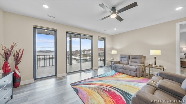 living room with light wood-type flooring and ceiling fan