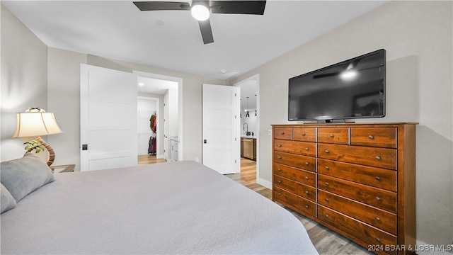 bedroom featuring ceiling fan, light hardwood / wood-style flooring, and sink