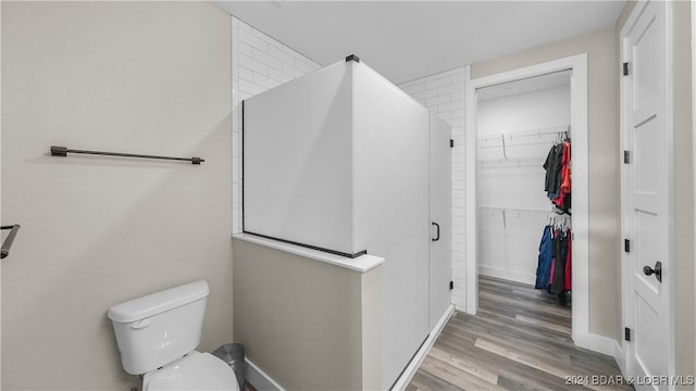 bathroom featuring wood-type flooring and toilet