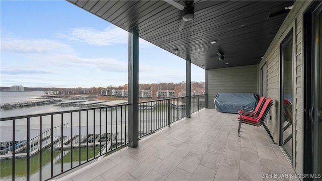 balcony with ceiling fan, area for grilling, and a water view