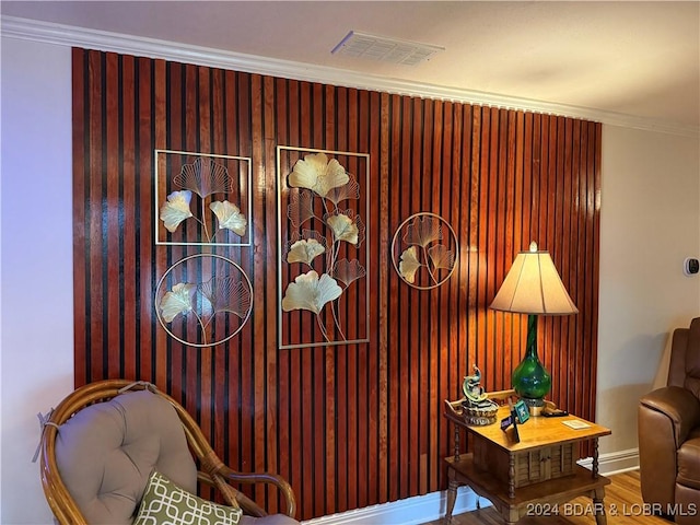 sitting room with hardwood / wood-style flooring and ornamental molding