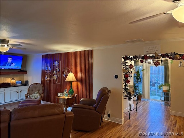 living room with hardwood / wood-style floors, ornamental molding, and ceiling fan