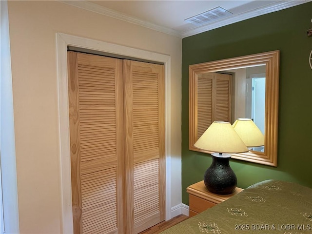 unfurnished bedroom with wood-type flooring, ornamental molding, and a closet