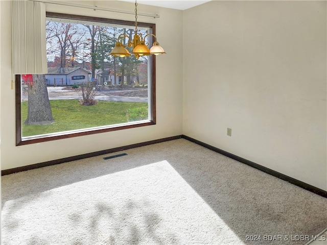 unfurnished dining area with carpet flooring and an inviting chandelier