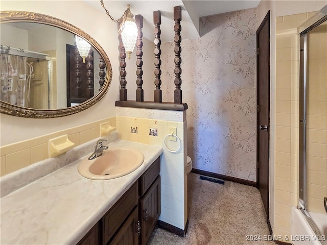 bathroom with vanity and bath / shower combo with glass door