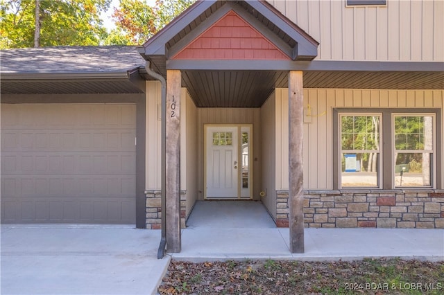 property entrance featuring a porch and a garage