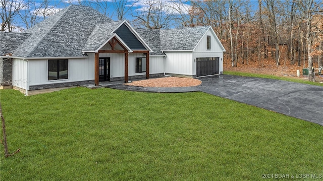 modern farmhouse style home featuring a front lawn and an outdoor structure