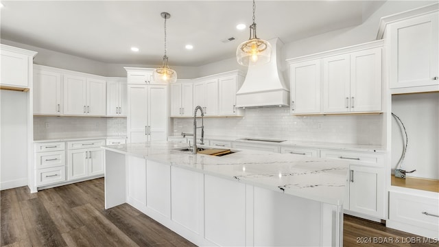 kitchen featuring white cabinets, custom range hood, and pendant lighting