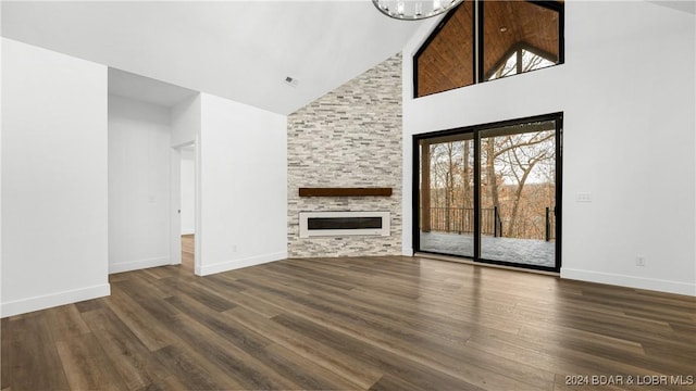 unfurnished living room featuring high vaulted ceiling, a fireplace, dark wood finished floors, and baseboards