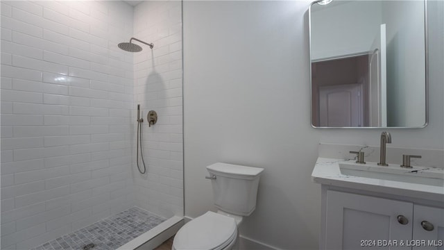 bathroom featuring toilet, a stall shower, and vanity