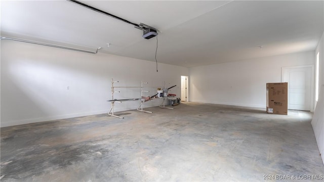 garage with baseboards and a garage door opener