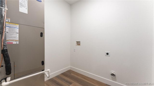 laundry area with laundry area, wood finished floors, heating unit, hookup for a washing machine, and hookup for an electric dryer