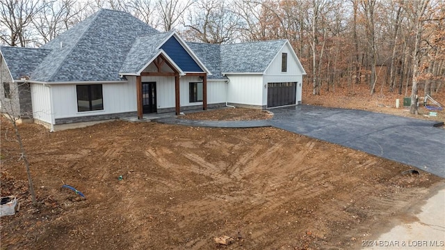 view of front of property with a shingled roof and driveway